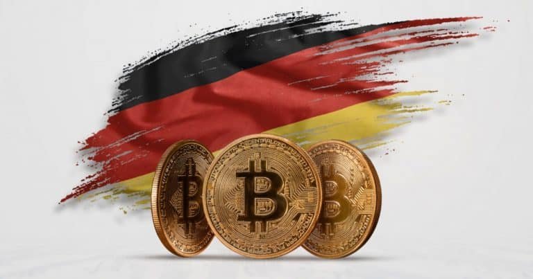 Three gold Bitcoin tokens stand in front of a brushstroke-style illustration of the German flag's black, red, and gold colors on a white background.