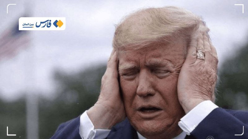 A blonde man in a dark suit covers both ears with his hands outdoors, with a Persian news logo in the corner.