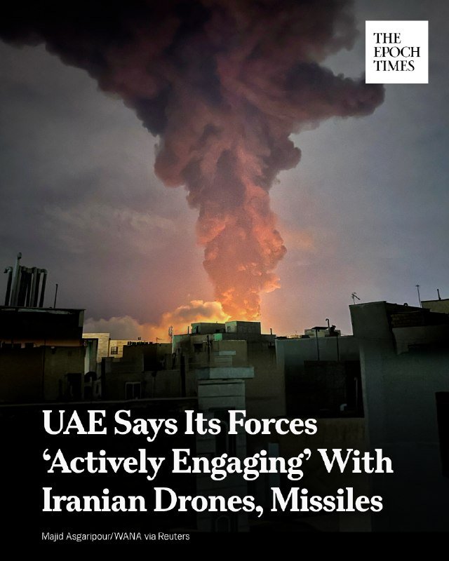 A large fire and thick plume of smoke rise above a city skyline of flat-roofed buildings in this Epoch Times news graphic.