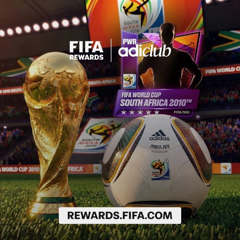 A golden FIFA World Cup trophy and an Adidas Jabulani match ball sit on grass in front of a stadium backdrop displaying South Africa 2010 branding.