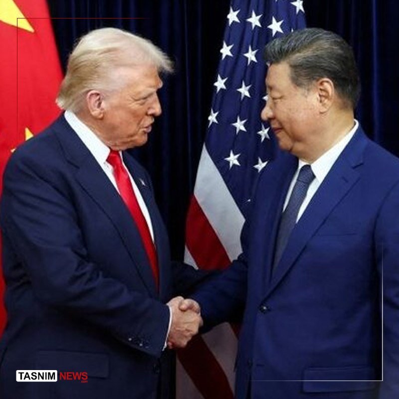 Two men in dark suits shake hands in front of American and Chinese flags, with "TASNIM NEWS" visible in the corner.