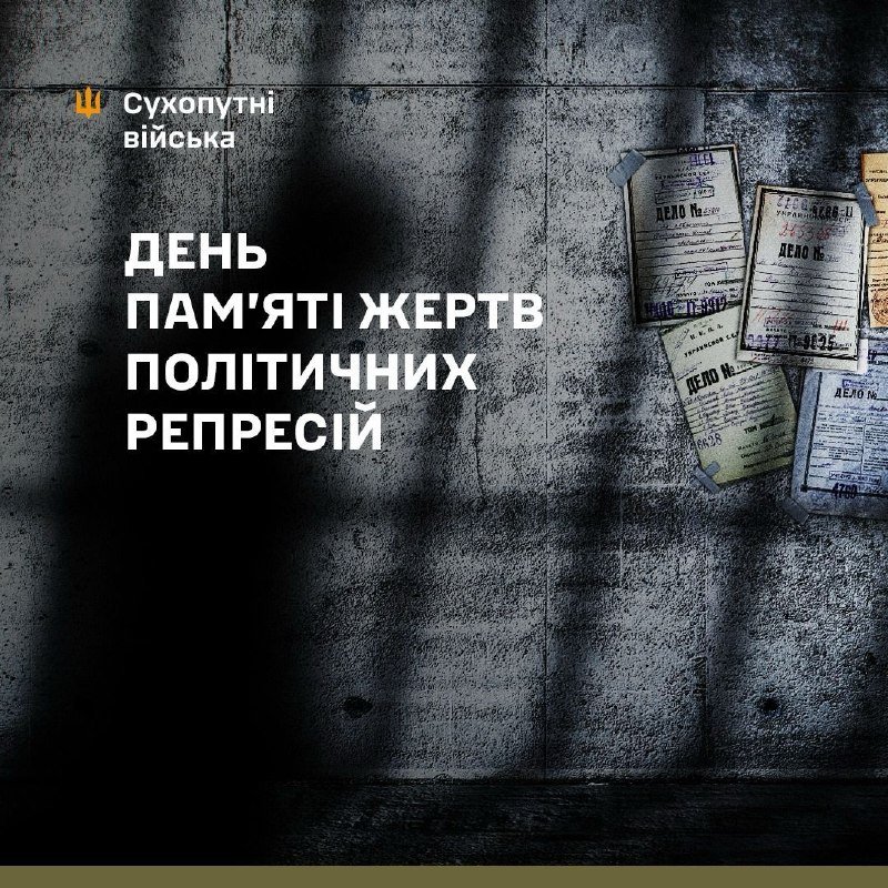 A graphic against a dark concrete wall displays Ukrainian text reading "День пам'яті жертв політичних репресій" alongside archival case-file documents taped to the surface.