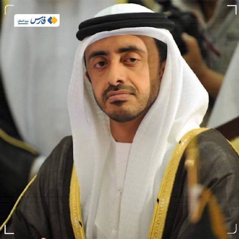 A man wearing traditional Gulf attire, including a white headdress and black bisht with gold trim, sits looking off-camera, with Arabic text overlaid in the upper left.
