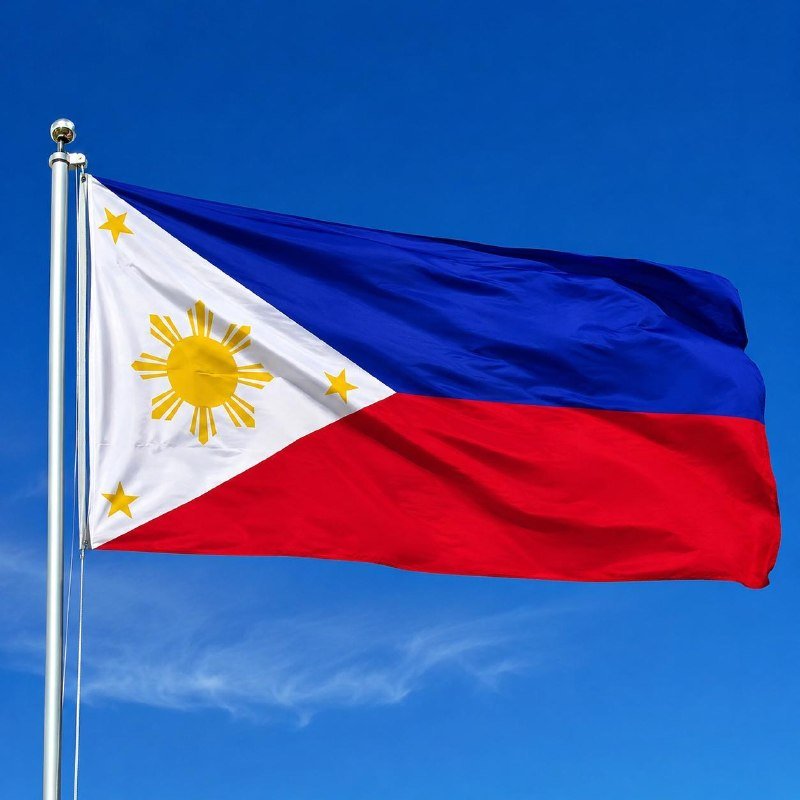 The flag of the Philippines, featuring a white triangle with a sun and stars alongside blue and red bands, waves on a flagpole against a clear blue sky.