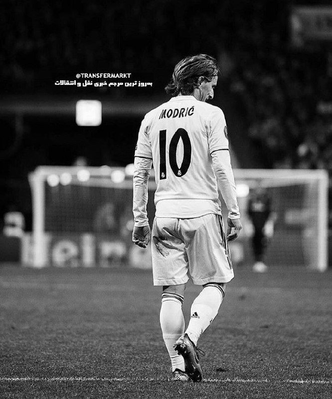 A black-and-white photo shows a soccer player wearing a jersey marked "MODRIĆ 10" walking on the pitch, with a goal and goalkeeper visible in the background.