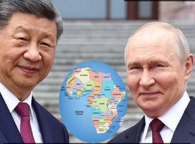 Two men in dark suits and ties smile at the camera, with a graphic illustration of a globe showing Africa positioned between them against a background of stone steps.