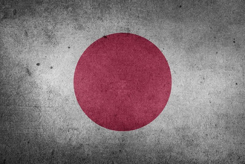 A textured illustration depicts a red circle centered on a weathered, gray concrete background resembling the flag of Japan.