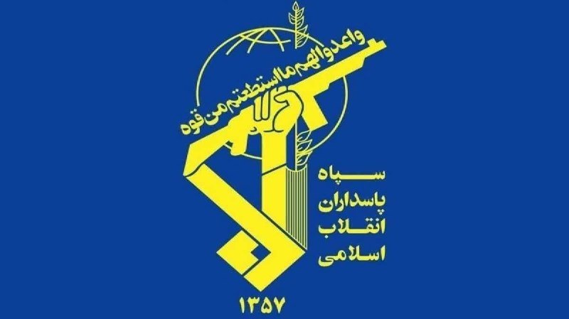 A yellow emblem on a blue background features a clenched fist holding a rifle, overlaid on a globe and stylized Iranian script, with the number "1357" displayed below.