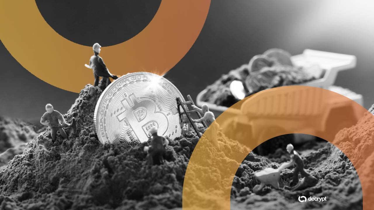 Illustration: miniature figures dig around a large Bitcoin on a dirt mound, with a wheelbarrow and a "decrypt" logo overlay.