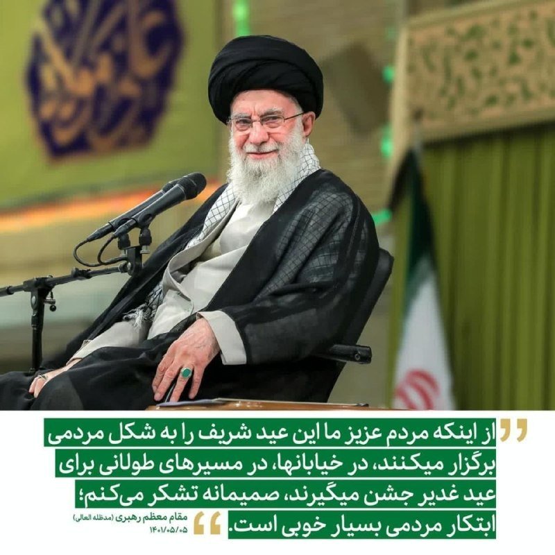 A white-bearded cleric in black robes and turban sits smiling before a microphone, with Persian text overlaid on the image.