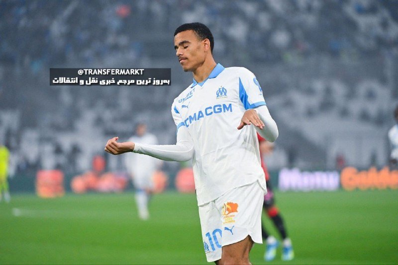 A soccer player in a white and blue Marseille kit with "CMA CGM" sponsorship celebrates on a rain-soaked pitch during a match, with blurred stadium crowds in the background.