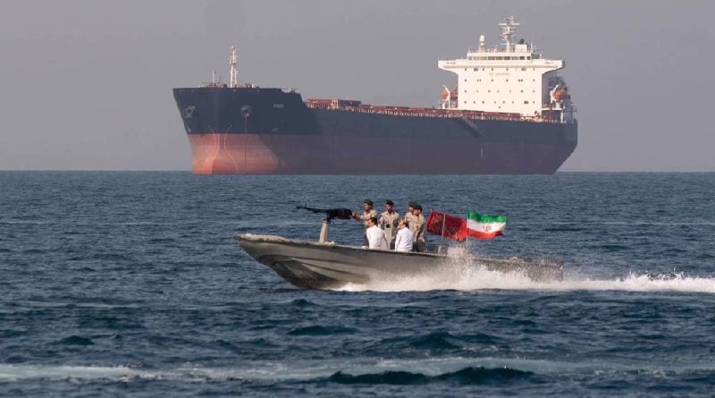 Three missiles with white nose cones are mounted on a launcher against a backdrop of the Iranian flag, with a news channel logo visible.