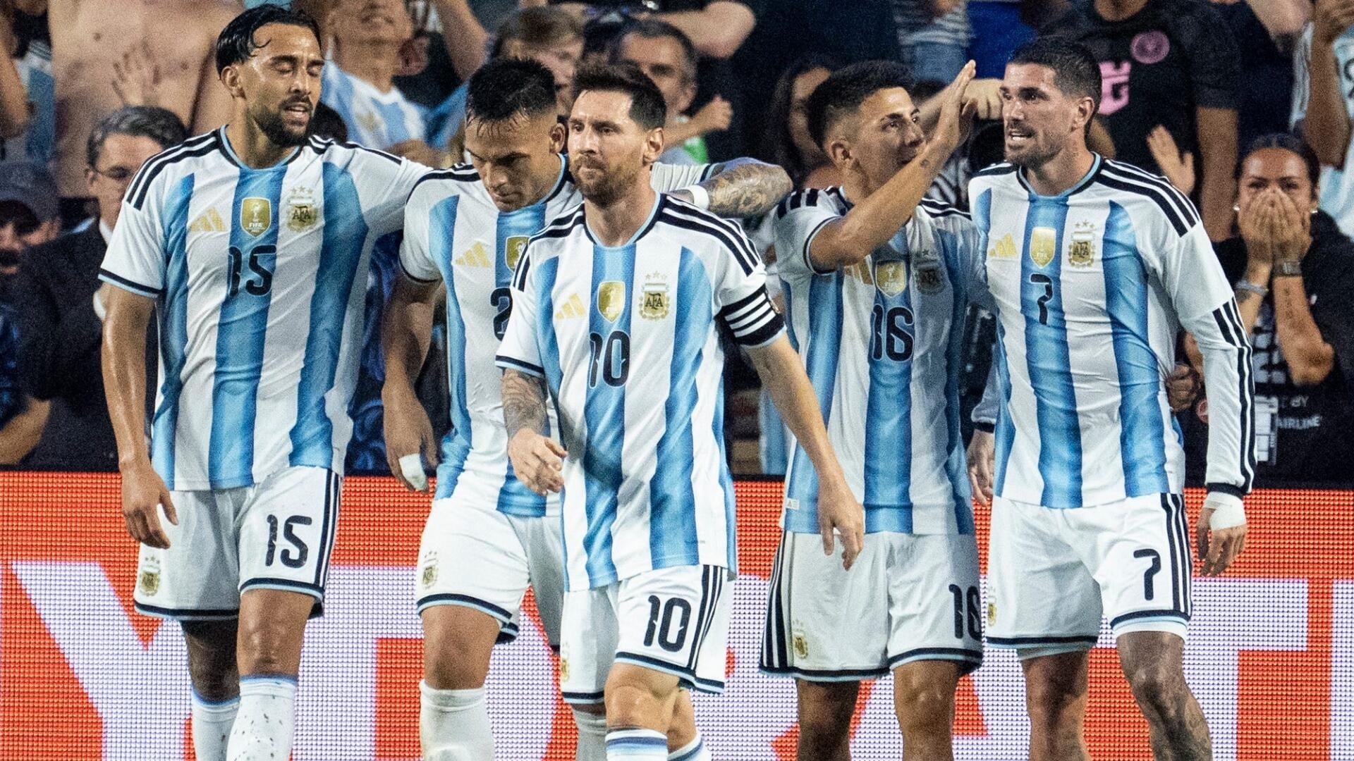 Two bald men in dark suits and blue ties look at each other while seated behind name placards reading "INFANTINO" and "MATT" against a blue background.