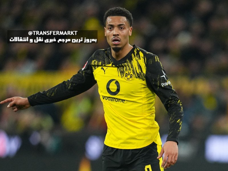 A Borussia Dortmund player in a yellow and black jersey with Vodafone and BVB 09 logos gestures on the pitch during a match.