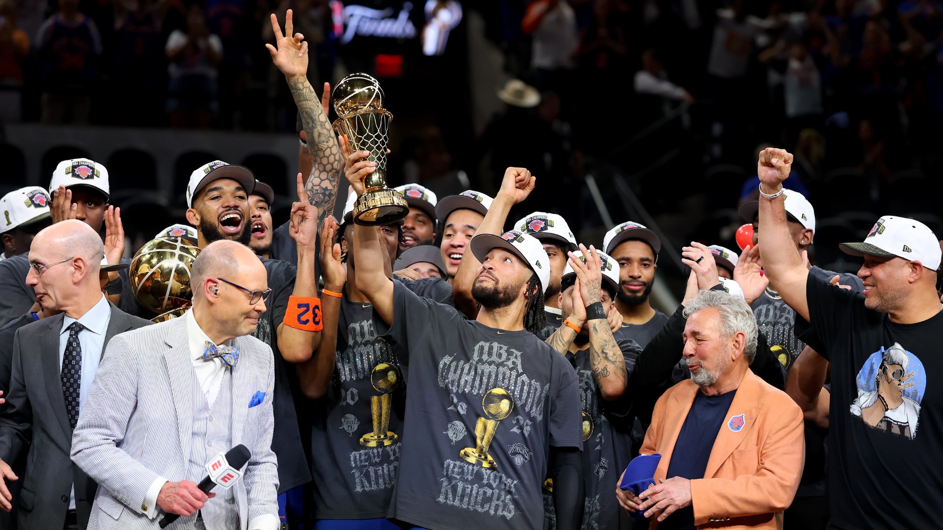 A graphic collage shows a smiling basketball player in a "Champions" hat, the same player kissing a golden NBA trophy, and teammates celebrating, with gold text reading "Emirates NBA Cup MVP, Eastern Conference Finals MVP, NBA Finals MVP."