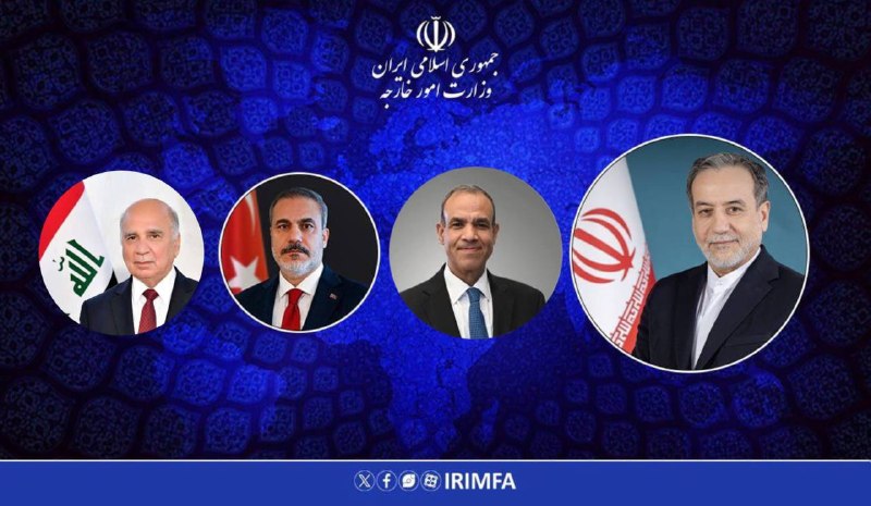 Four men in dark suits sit in ornate gold-trimmed armchairs across from each other in a formal room, with small Iranian and Pakistani flags displayed on a table between them.