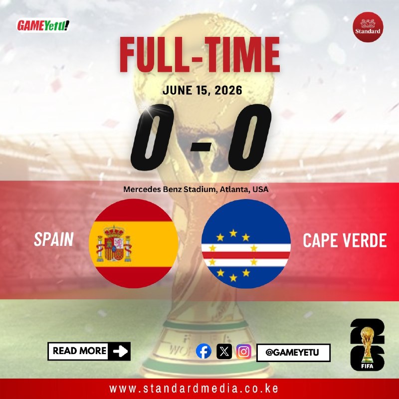 Gray-haired man in white France training top walks past players in blue kits.