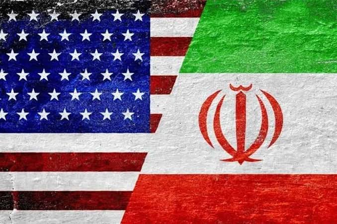 Graphic illustration of the United States and Iranian flags painted side-by-side on a textured wall.