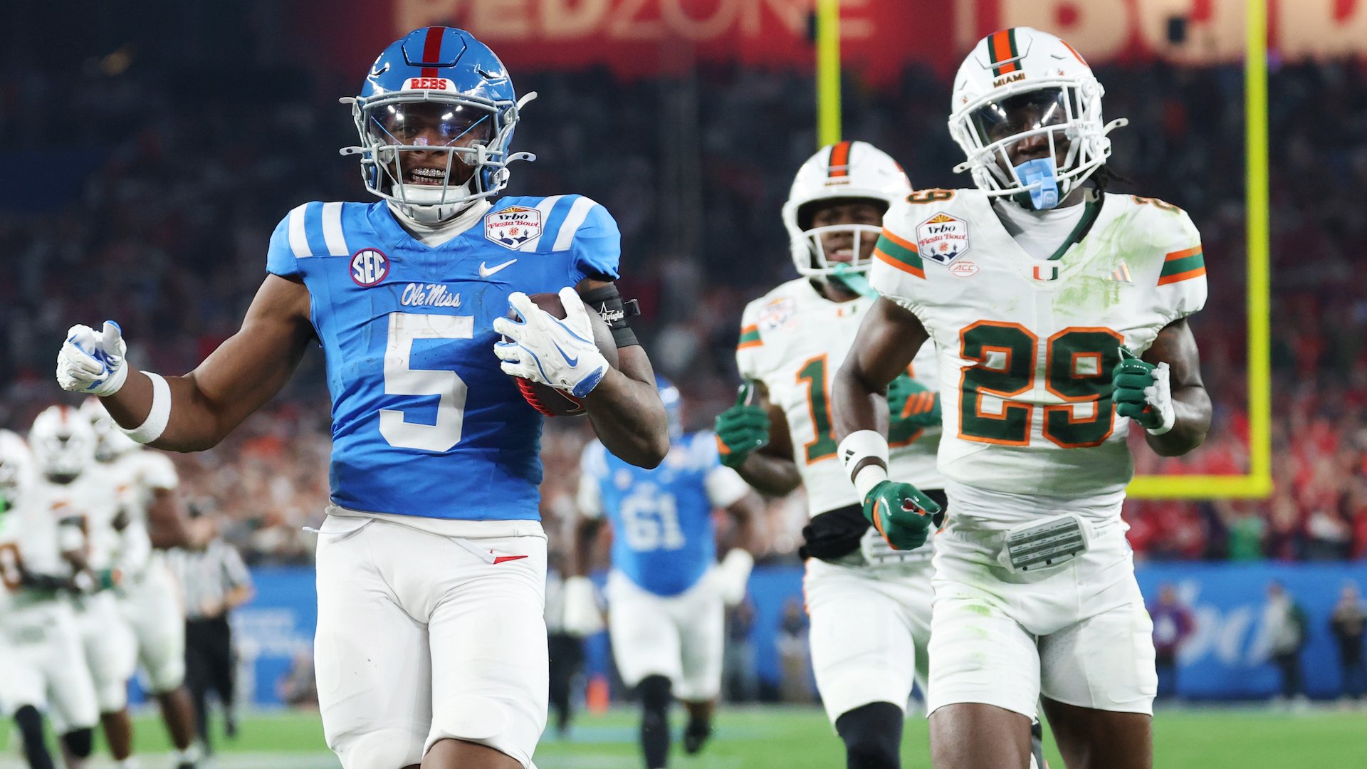 An Ole Miss football player wearing jersey number 5 carries the football while running past Miami defenders during a college football game.