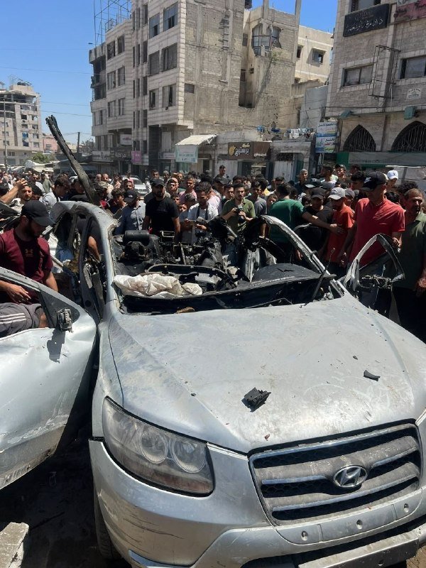 The image contains two frames: the top shows a bearded man wearing a black cap and beige vest speaking indoors, with Arabic text overlay; the bottom shows a body lying on a debris-strewn outdoor street.