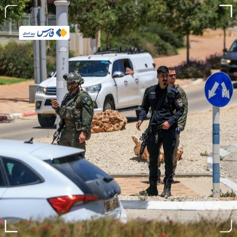 Three armed personnel in military-style uniforms stand on a roadside near a white pickup truck and a parked car, with a blue traffic sign nearby.