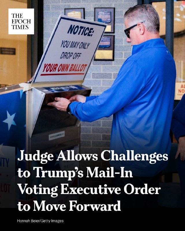 A man in a blue jacket drops off his ballot at a ballot drop box marked "NOTICE: YOU MAY ONLY DROP OFF YOUR OWN BALLOT."