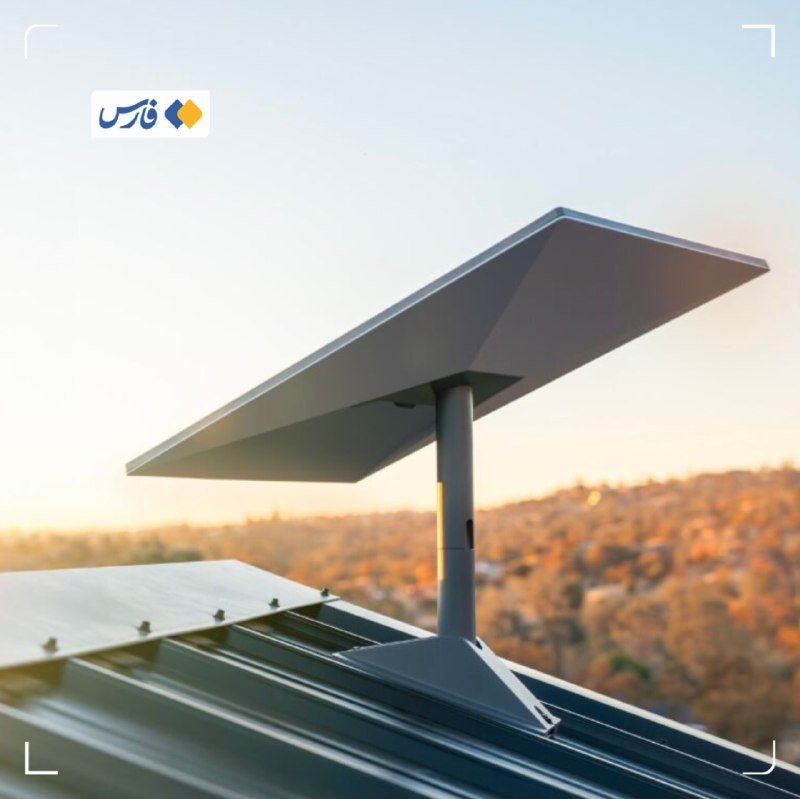 A Starlink satellite dish is mounted on a rooftop against a hazy sky with hills visible in the background.