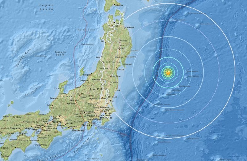 A topographical map of Japan and surrounding waters displays a yellow and green epicenter off the eastern coast, marked by concentric white and blue rings indicating seismic intensity.