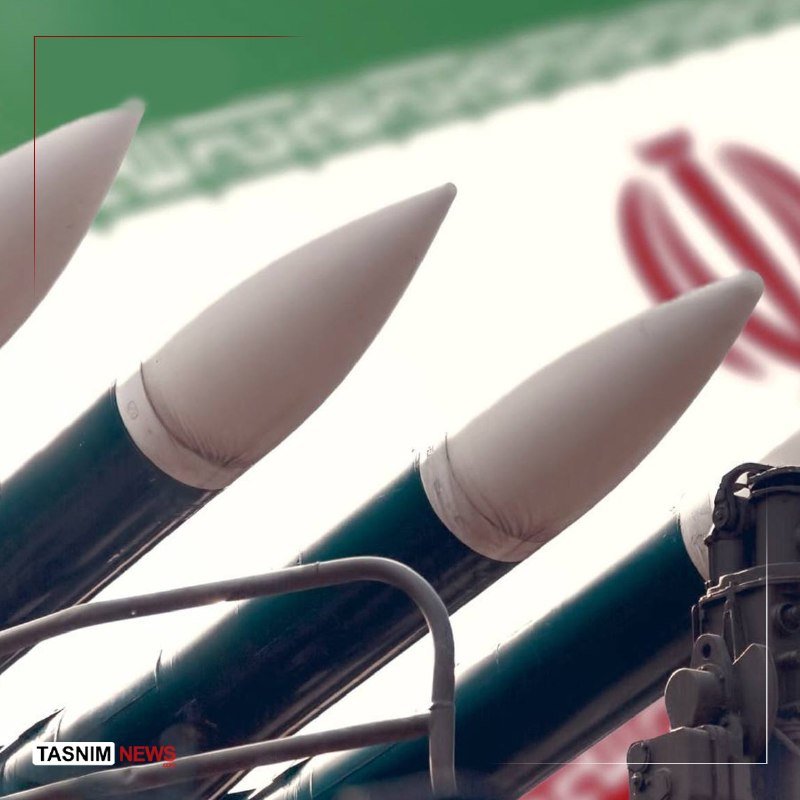 Missiles with white nose cones displayed against a green, white, and red flag backdrop, with a "Tasnim News" watermark.