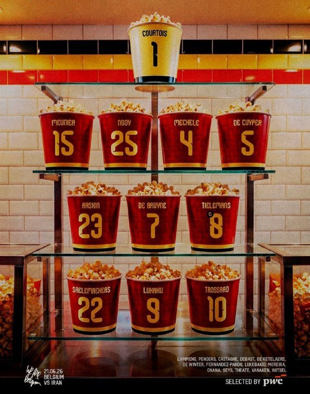 Red and gold buckets filled with popcorn, each labeled with a player's name and number, are displayed on tiered glass shelves beneath a white tile wall.