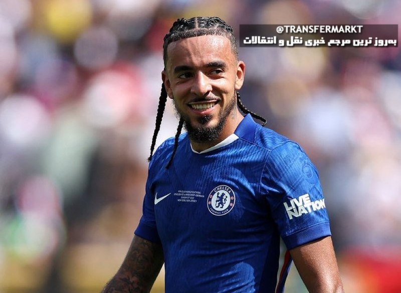 A smiling man with braided hair wearing a blue Chelsea Football Club jersey stands in a stadium setting, with a Transfermarkt Persian text overlay in the corner.