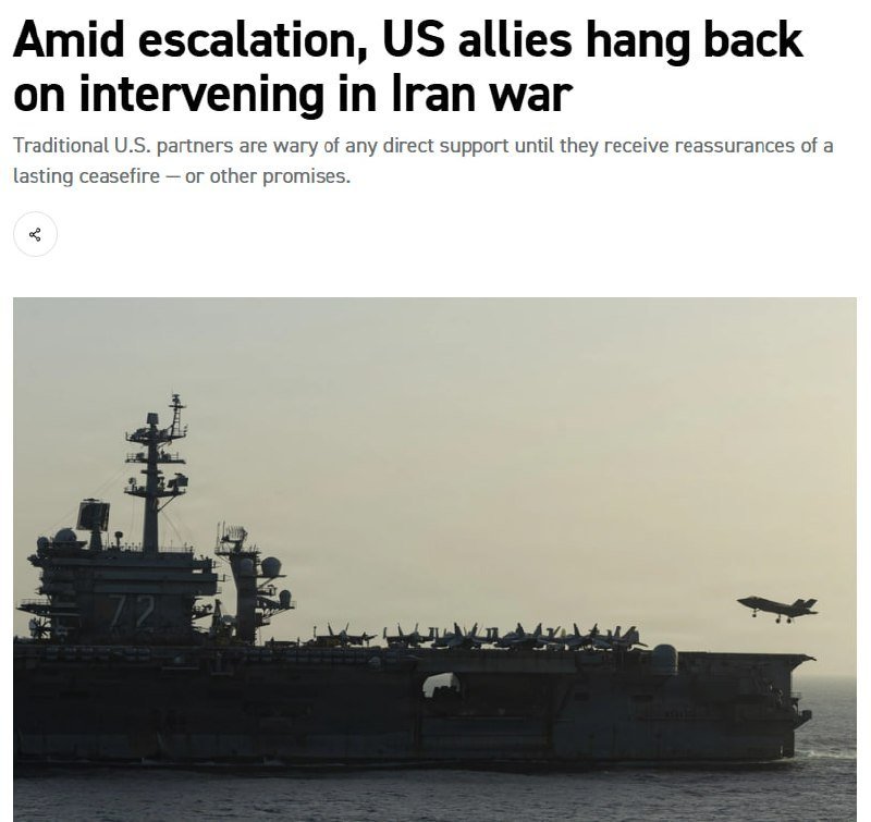 A large naval aircraft carrier marked "72" sits at sea at dusk, with a fighter jet approaching for landing over its deck.