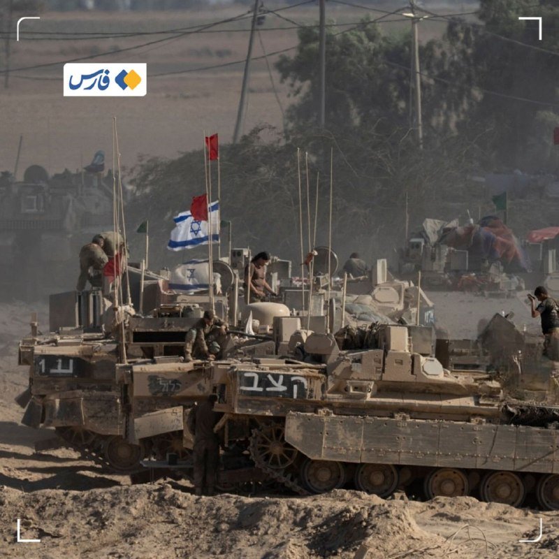 A military vehicle carries a large group of blindfolded, shirtless men through a barren landscape, with a soldier standing atop the vehicle.