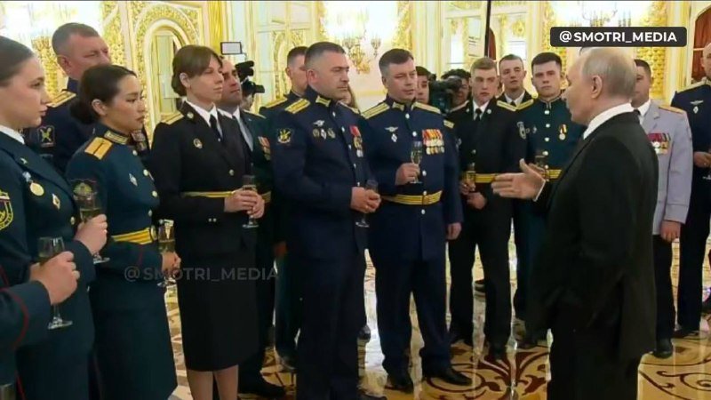 A man in Ukrainian military camouflage uniform sits at a table holding papers, with an "Armed Forces of Ukraine" emblem visible on the wall behind him.