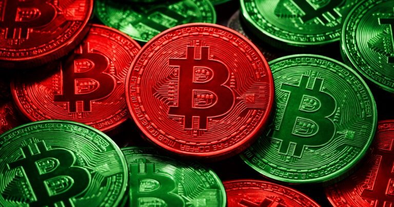 Close-up of physical Bitcoin-style tokens in red and green with the "B" logo and "Decentralized" text visible.