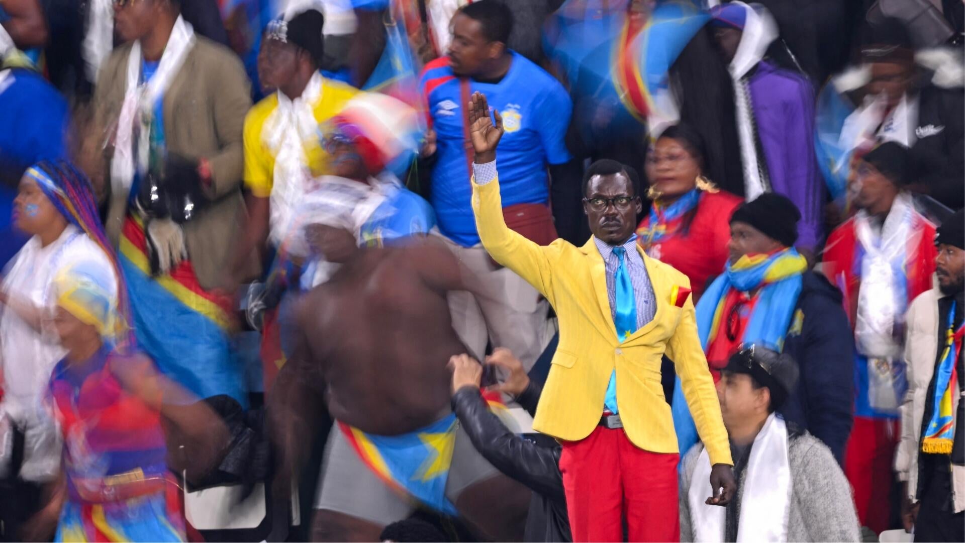 A soccer player in an orange jersey celebrates with a raised fist, shown above a graphic displaying a 0-2 FIFA World Cup 2026 final score.