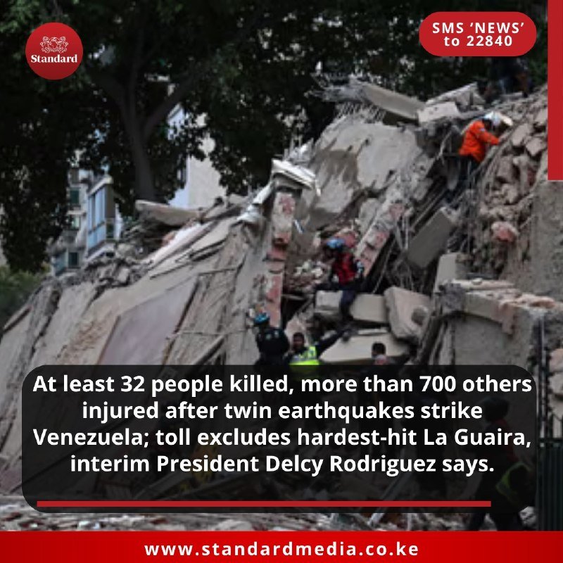 Rescue workers in helmets and high-visibility vests climb over a large pile of concrete and building debris from a collapsed structure.