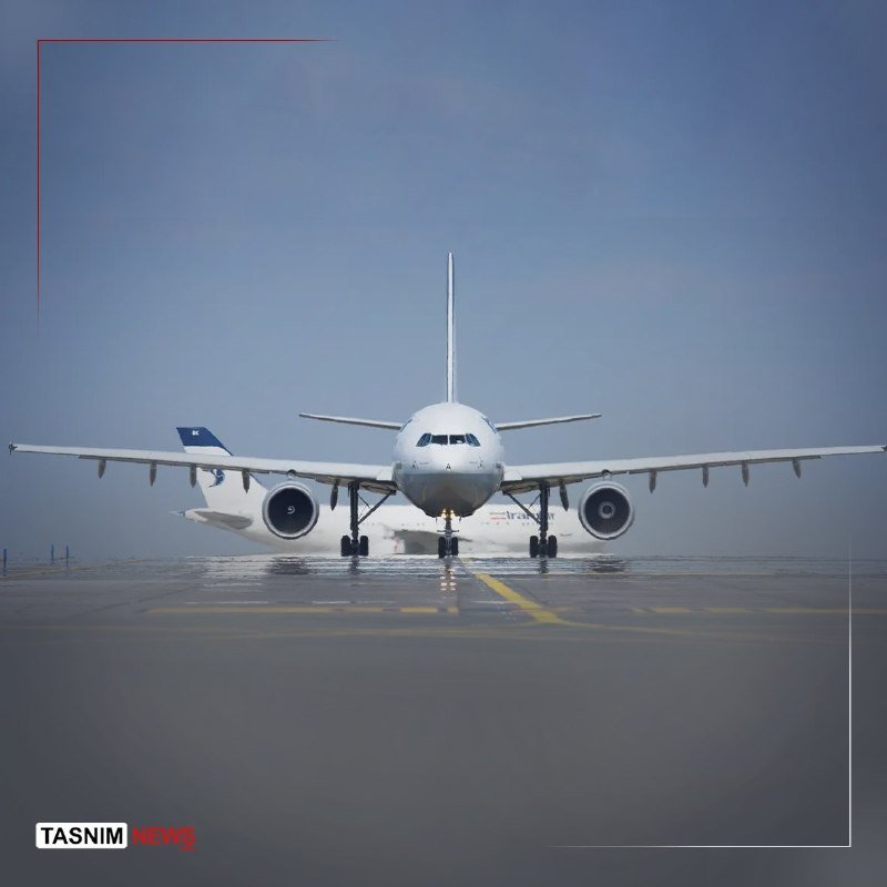 A commercial passenger jet taxis on a wet runway under a hazy sky, with the Tasnim News logo visible in the corner.