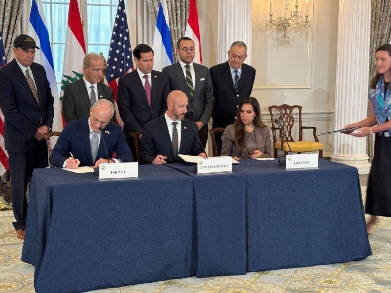 Military personnel in camouflage uniforms sit at a table before a "Military Strategic Partner Dialogue" banner and various national flags.