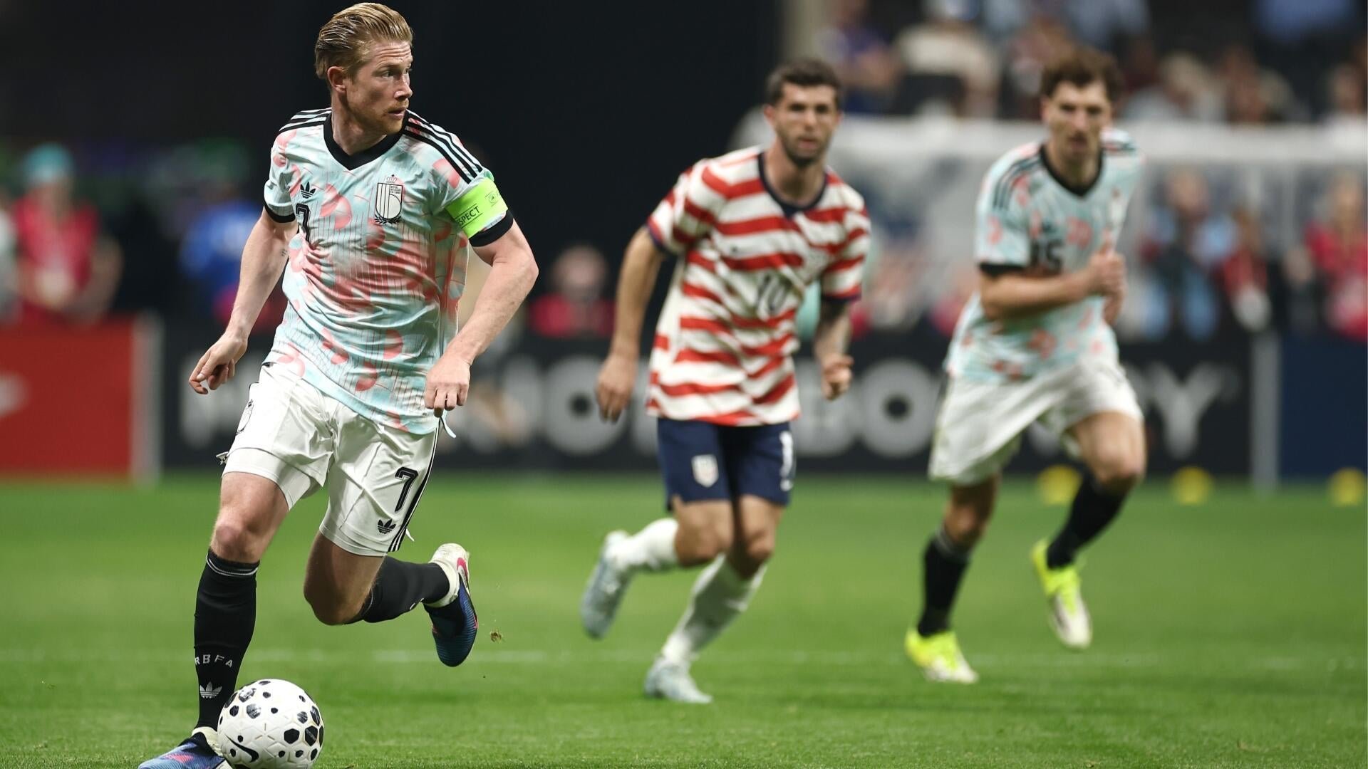 A graphic illustration shows a standing soccer player in a red-and-white checkered #10 jersey pulling up a seated player in a red #7 jersey, beneath the text "One Last Time."