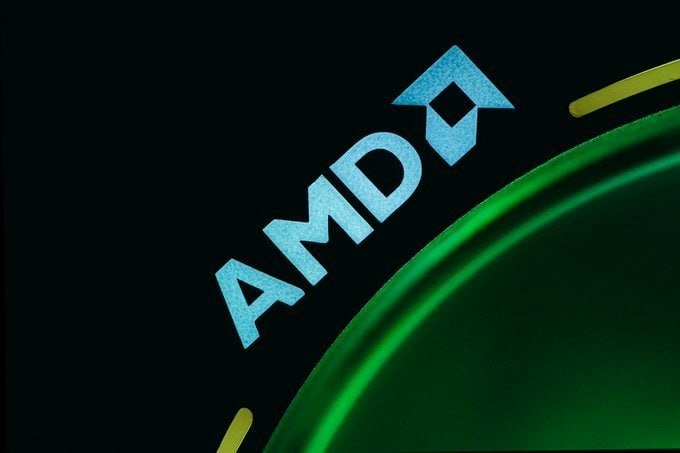 Graphic featuring a light-blue "AMD" logo with an arrow symbol against a black background beside a green circular element.