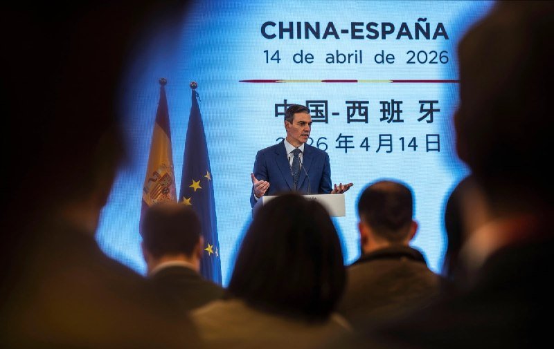 A man speaks at a podium on a large blue stage displaying "2026 World AI Conference & High-Level Meeting on Global AI Governance, July 17, 2026, Shanghai, China," before a seated audience.