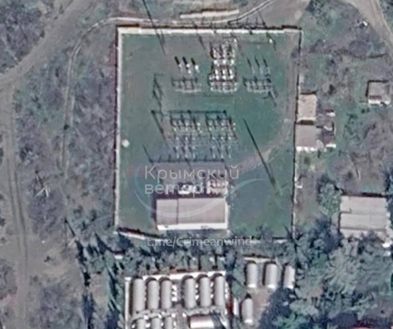 A satellite image shows a fenced compound containing transformer equipment and a small building, with rows of cylindrical tanks below and Cyrillic watermark text overlaid.
