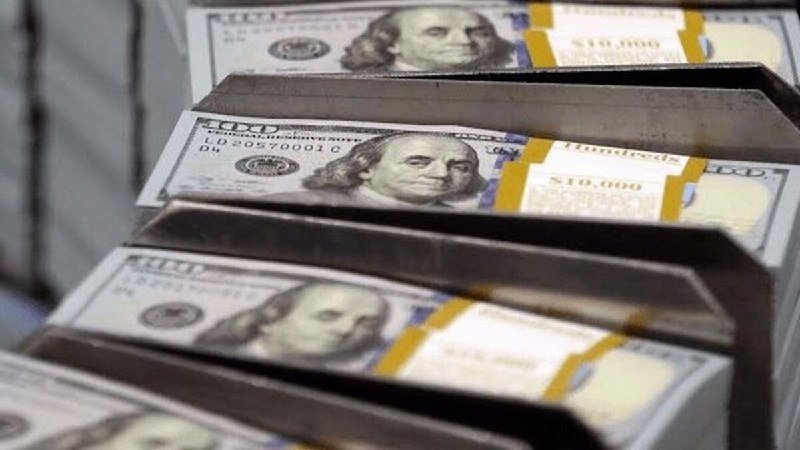 Stacks of $100 U.S. bills, each banded and marked "$10,000," sit in a row inside a metallic container.