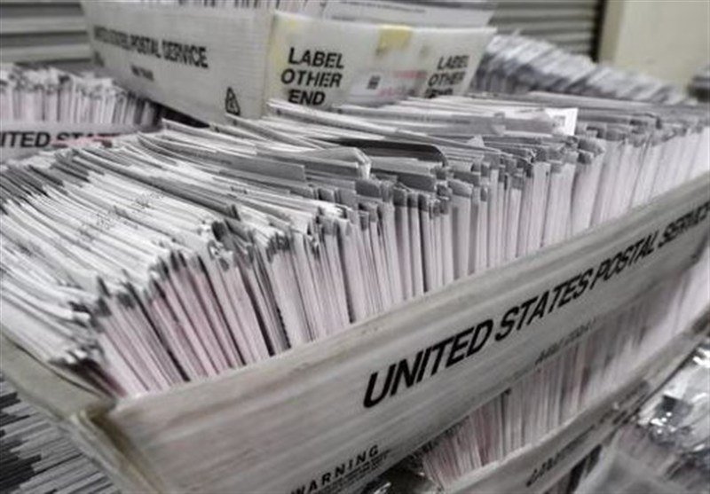 Stacks of mail bundled in "United States Postal Service" trays filled with letters marked "Label Other End."
