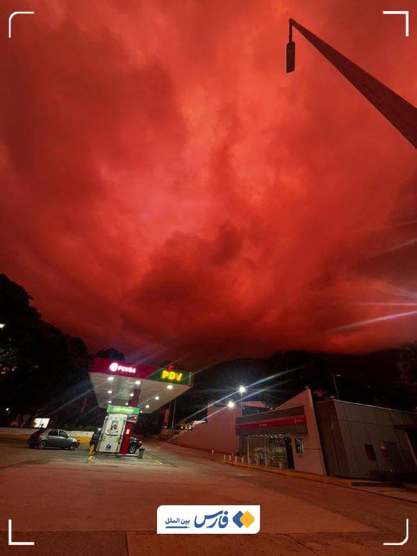 Rescue workers in red shirts and blue caps sift through a large pile of concrete and building debris at dusk.