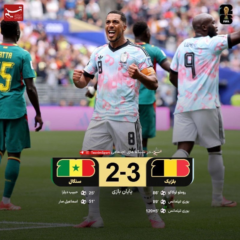 A referee in a green jersey holds up a red card while facing a soccer player wearing a white jersey with "REAM" and the number 13 on the back.