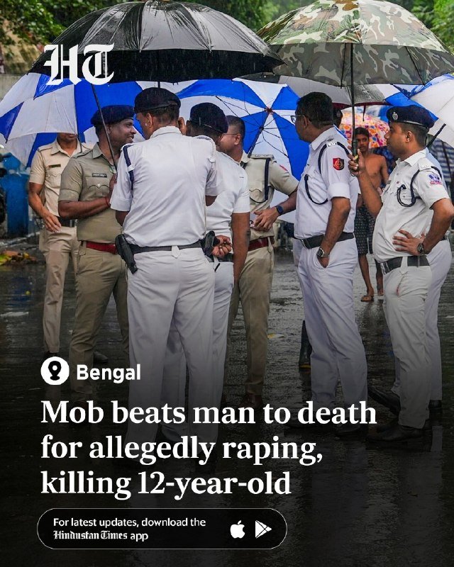 Police officers in khaki and white uniforms stand under umbrellas in the rain, gathered together on a wet street in Bengal.