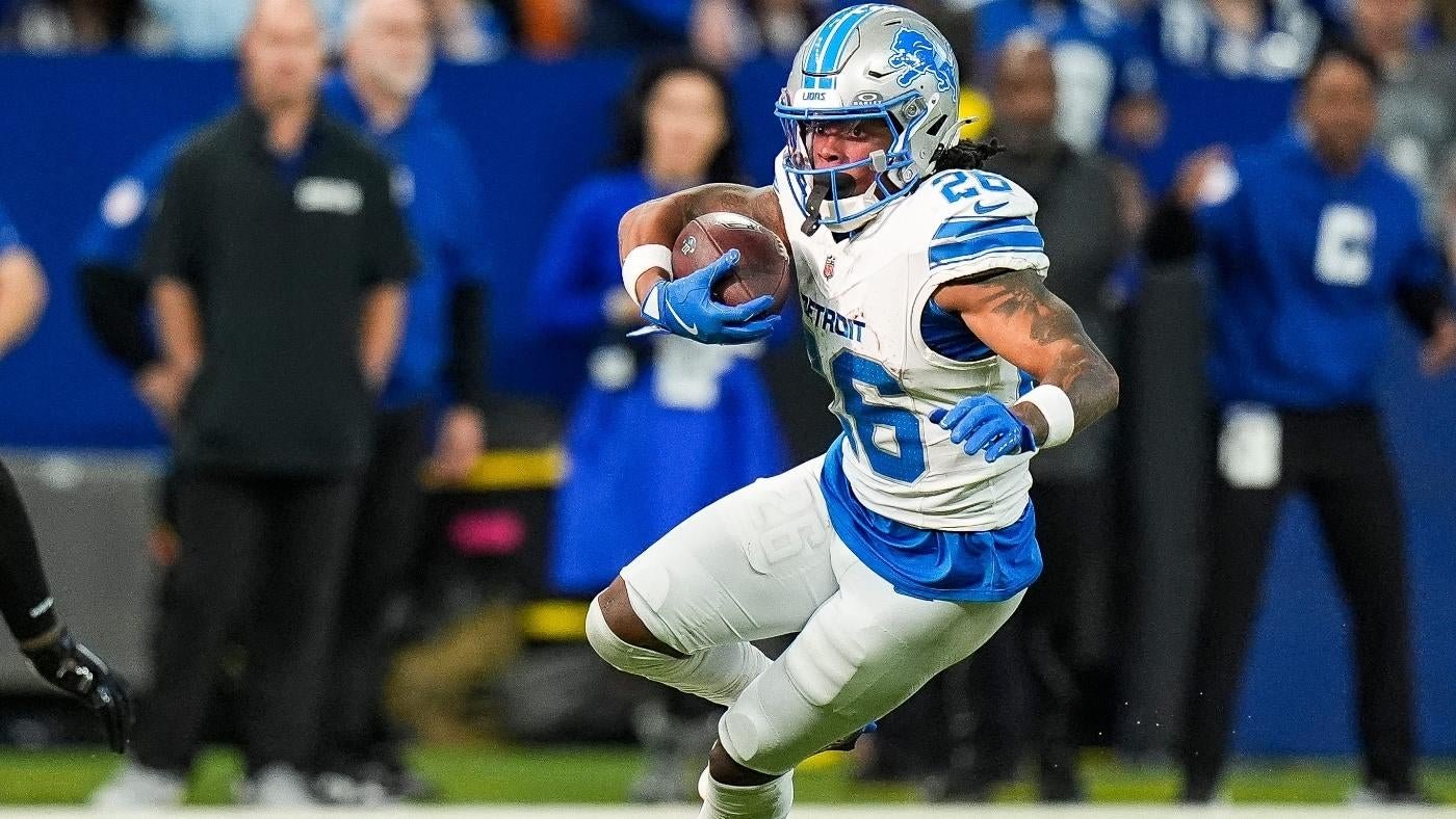 A Detroit Lions football player wearing jersey number 28 runs with the ball tucked under his arm during a game.