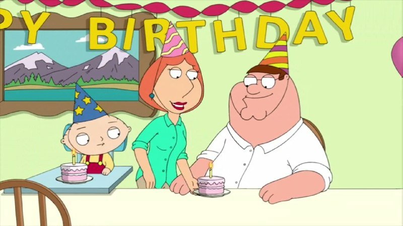 Animated cartoon scene showing a family of three wearing party hats at a table with small cakes, beneath a "Happy Birthday" banner and streamers.
